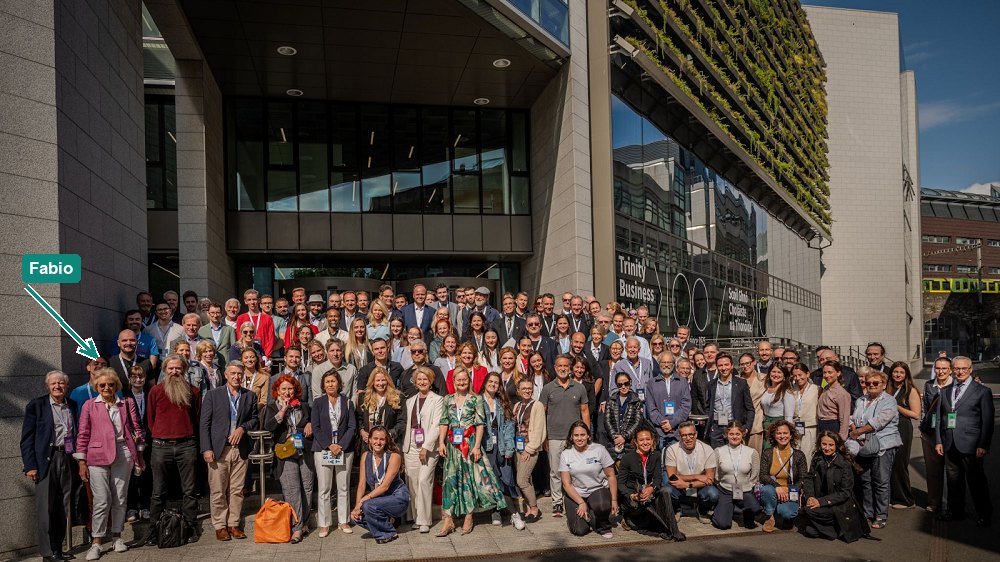 Group photo of the 2025 Longevity Summit Dublin attendees outside the Trinity Business School, with Fabio Pietrosanti marked by an arrow in the front rows